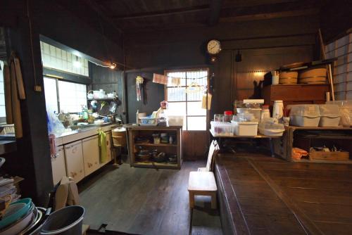 a kitchen with a counter and a person in the window at Kamiya Rare Experience in a 180 Year Old Farmhouse Milky Way Irori Fire and Nature! in Iida