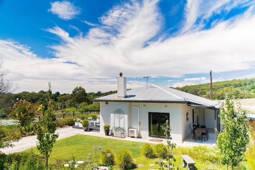 a white house with a lawn and trees at Esto house in Crafers
