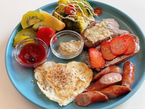 a blue plate of breakfast food with eggs toast and fruit at Square B&B in Taitung City