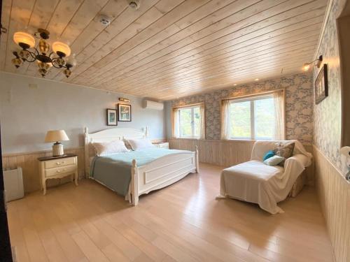 una camera da letto con un letto, un divano e una sedia di Good Time B&B a Jiufen