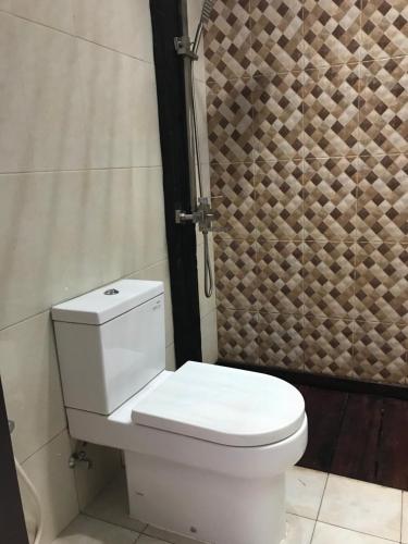 ein weißes WC im Bad mit Dusche in der Unterkunft Villa Ulin A3 at Villa Ubud Anyer in Serang