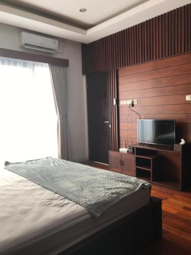ein Schlafzimmer mit einem Bett und einem Flachbildfernseher in der Unterkunft Villa Ulin A3 at Villa Ubud Anyer in Serang