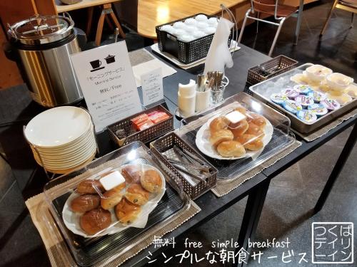 a table with several trays of donuts on it at Tsukuba Daily Inn in Tsukuba