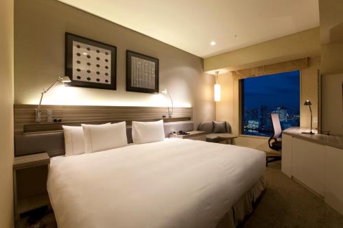 1 cama blanca grande en una habitación con ventana en The Royal Park Hotel Iconic Tokyo Shiodome, en Tokio
