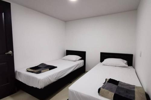サン・ラファエルにあるHermoso y cómodo apartamentoのベッド2台が隣同士に設置された部屋です。