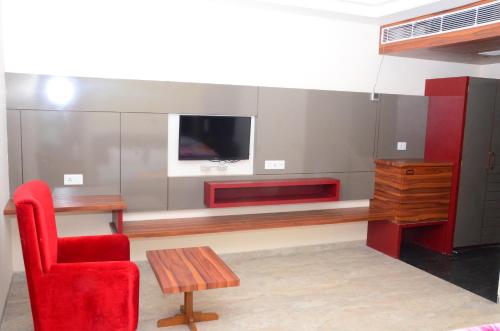 a living room with a desk and a red chair at DUDI HOTEL in Bikaner