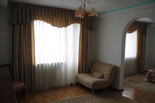 a living room with a chair and a window at Green Hotel in Almaty