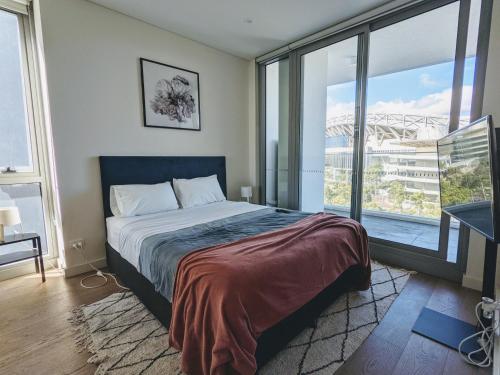ein Schlafzimmer mit einem Bett und einem großen Fenster in der Unterkunft Luxury 3-bed 2-bath, balcony, with pool included, NO PARTIES! in Sydney