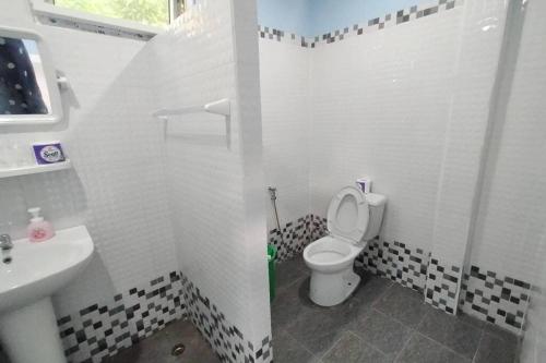 La salle de bains blanche est pourvue de toilettes et d'un lavabo. dans l'établissement Jayden's HomeStay, à Ko Sukon