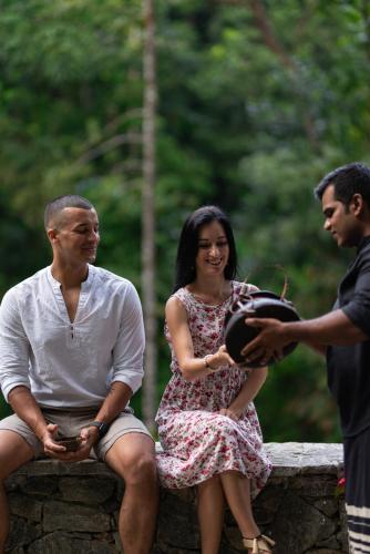 a man and a woman sitting on a wall at Moksha at Kitulgala - Rainforest Boutique Hotel in Kitulgala