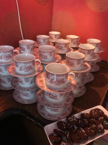 a group of cups and saucers on a table with cookies at Hotell Plevnagården in Malmköping