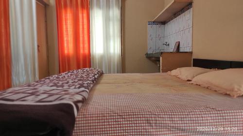 Cette chambre comprend un grand lit et une fenêtre. dans l'établissement Yogi Home Stay, à Rishikesh