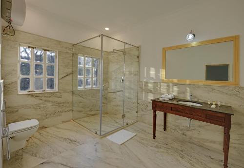 een badkamer met een douche, een wastafel en een toilet bij The Mount Bungalow Mount Abu in Mount Ābu