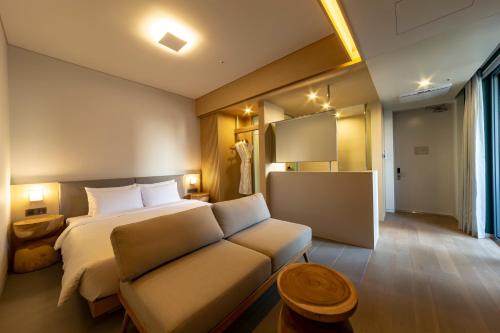 a hotel room with a bed and a couch at Hound Hotel Haeundae Signature in Busan