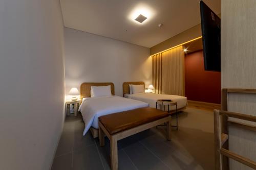 a hotel room with two beds and a television at Hound Hotel Haeundae Signature in Busan