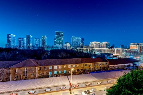 a building in front of a city at night at Happy Dragon Universal Vacation Hotel - close to Universal Studio and Wanda Plaza,free shuttle to the Resort,Free Coffee,Laundry in Beijing