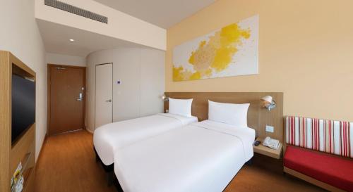 a hotel room with two beds and a tv at ibis Pune Hinjewadi - An Accor Brand in Pune