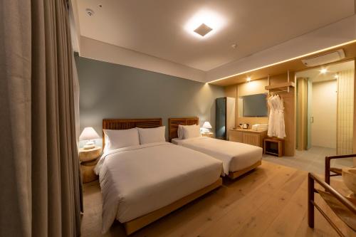 a hotel room with two beds and a bathroom at Hound Hotel Haeundae Signature in Busan