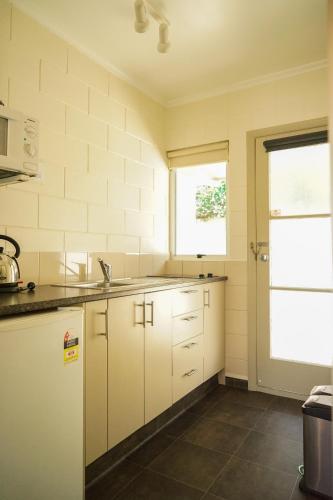 a kitchen with white cabinets and a sink at Montana Lodge Motel in Blenheim