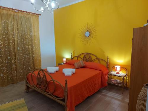 una camera con un letto rosso e una parete gialla di Terrazza New Homes a Castellammare del Golfo