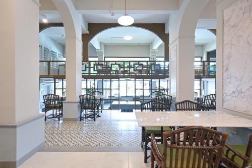 ein Esszimmer mit Stühlen und Tischen in einem Gebäude in der Unterkunft The Krungkasem Srikrung Hotel in Bangkok