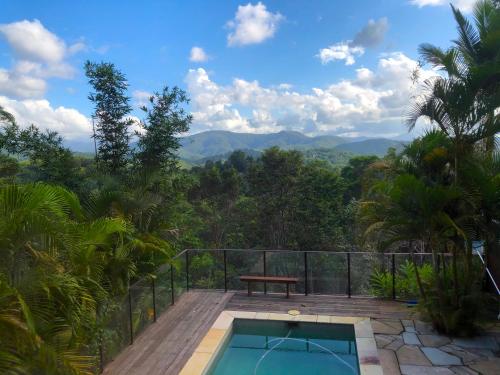 a house with a swimming pool and a bench on a balcony at THE GOLDEN RETREAT POOL HOUSE in Uki