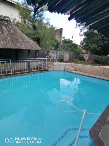 a large blue swimming pool in front of a house at Lytton Cresent B&B in Pinetown