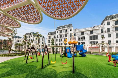 ハイフォンにあるChuỗi căn hộ Merci Apartment & Homestay - Vinhomes Imperia Hai Phongの背景の建物が立ち並ぶ公園内の遊び場