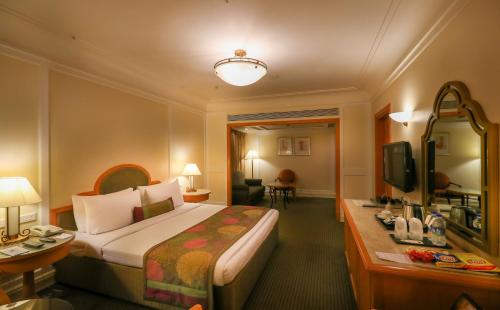 a hotel room with a bed and a television at The Imperial Palace in Rajkot