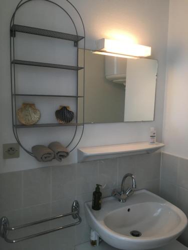 La salle de bains est pourvue d'un lavabo et d'un miroir. dans l'établissement Studio cocooning, à Saint-Malo