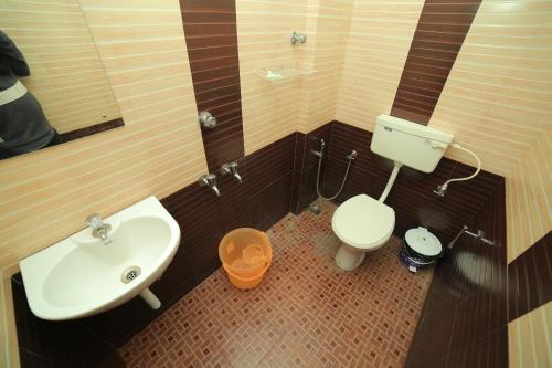 a bathroom with a sink and a toilet at Hotel Falcon in Trivandrum