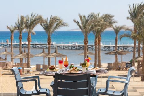 a table with food and drinks on the beach at Pickalbatros Palace - Aqua Park Hurghada in Hurghada