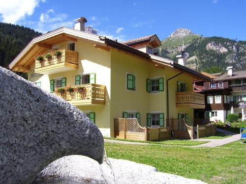 a building with a water fountain in front of it at Residence Ercabuan in Campitello di Fassa