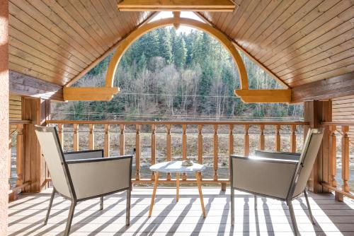 a room with a table and chairs on a deck at Клуб Яремчанський Шале in Yaremche