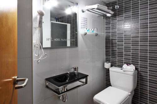 La petite salle de bains est pourvue de toilettes et d'un lavabo. dans l'établissement Hotel Nuevo Triunfo, à Barcelone