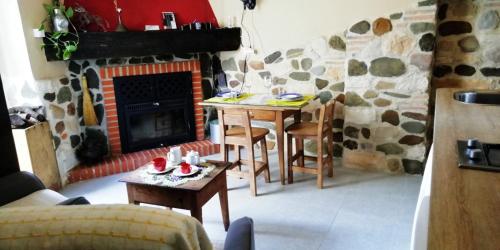 ein Wohnzimmer mit Tisch und Kamin in der Unterkunft Casa Rural Abuela Maxi in Ríolobos