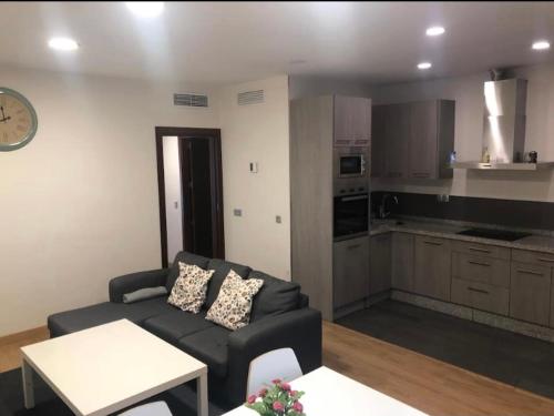 ein Wohnzimmer mit Couch und Küche in der Unterkunft GAV Remedios 20 in Ronda