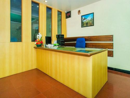 an office with a reception counter with a blue chair at hotelpearlinn in Bengaluru