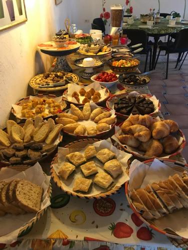 a table full of different types of bread and pastries at CA' LA SOMARA in San Pantaleo