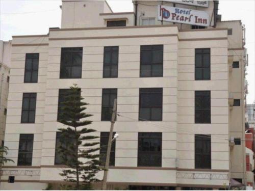 a white building with a sign on top of it at hotelpearlinn in Bengaluru
