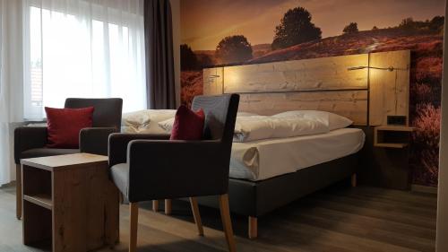 a bedroom with a bed and a couch and a chair at Hotel-Restaurant Zur Linde in Secklendorf