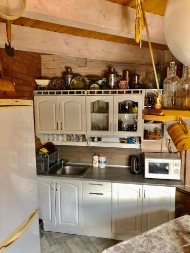 a kitchen with white cabinets and a sink at "Будиночок гедоніста" in Tukhlya