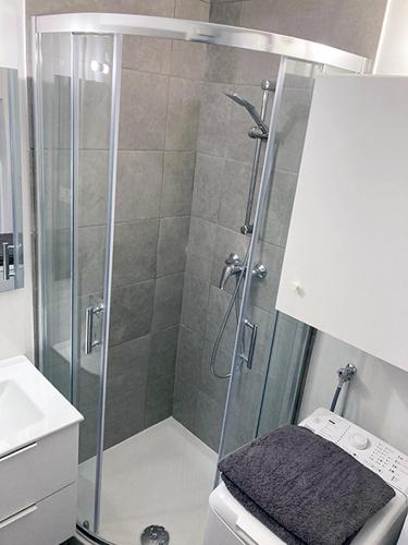 une douche avec une porte vitrée dans une salle de bain dans l'établissement Apartment with Sea View, à La Seyne-sur-Mer