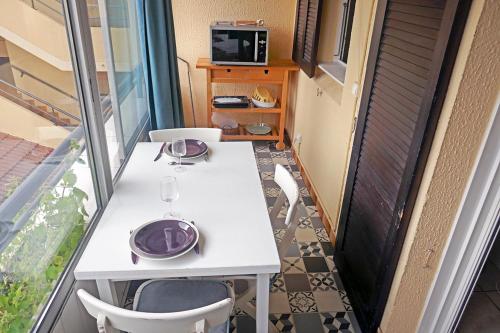 - une table blanche avec des plaques violettes sur le balcon dans l'établissement Apartment with Sea View, à La Seyne-sur-Mer