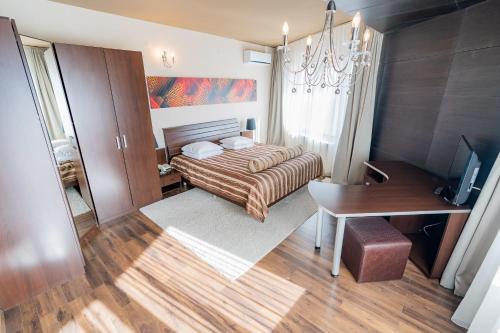 a small bedroom with a bed and a desk and a desk at Hotel Belvedere in Braşov