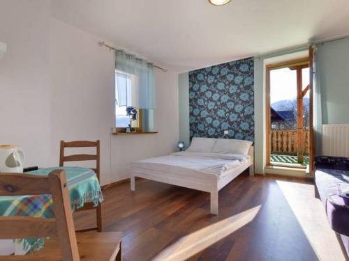 a bedroom with a bed and a window with a balcony at Pensjonat Astor in Karpacz