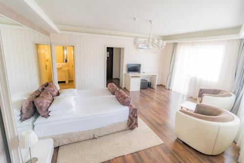 a living room with a white couch and chairs at Hotel Belvedere in Braşov