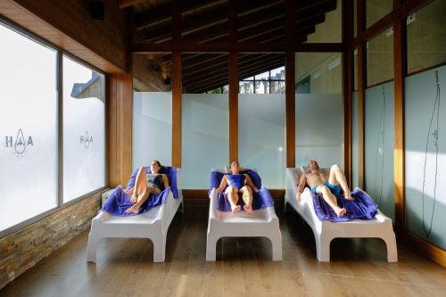 three women laying in beds in a room with windows at Snö Aragon Hills in Formigal