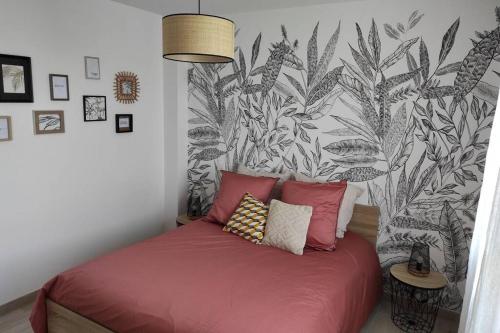 ein Schlafzimmer mit einem roten Bett und einer schwarz-weißen Tapete in der Unterkunft Au bonheur des Landes Logement neuf tout confort proche forêt et ville in Colombiers