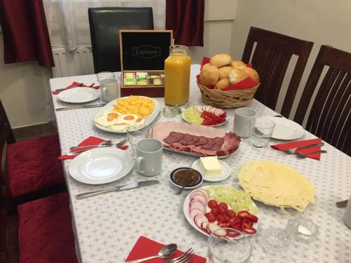 a table with plates of food and a basket of bread at Kikerics vendégház in Villány